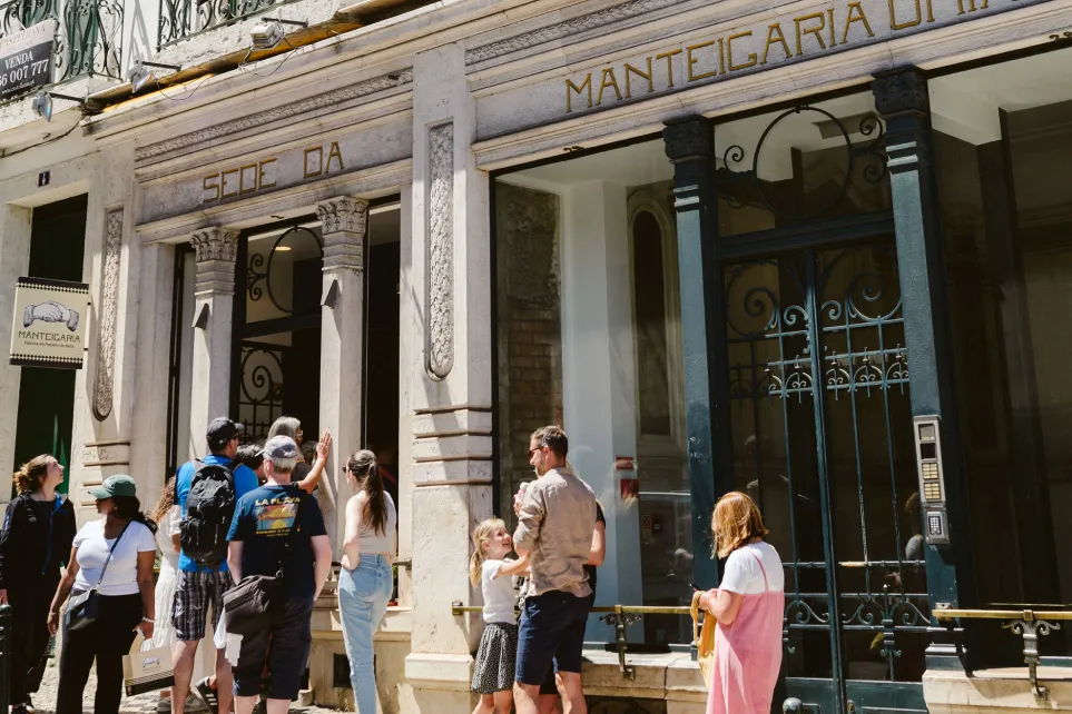 Pessoas à entrada da Manteigaria no Chiado, num dia de sol