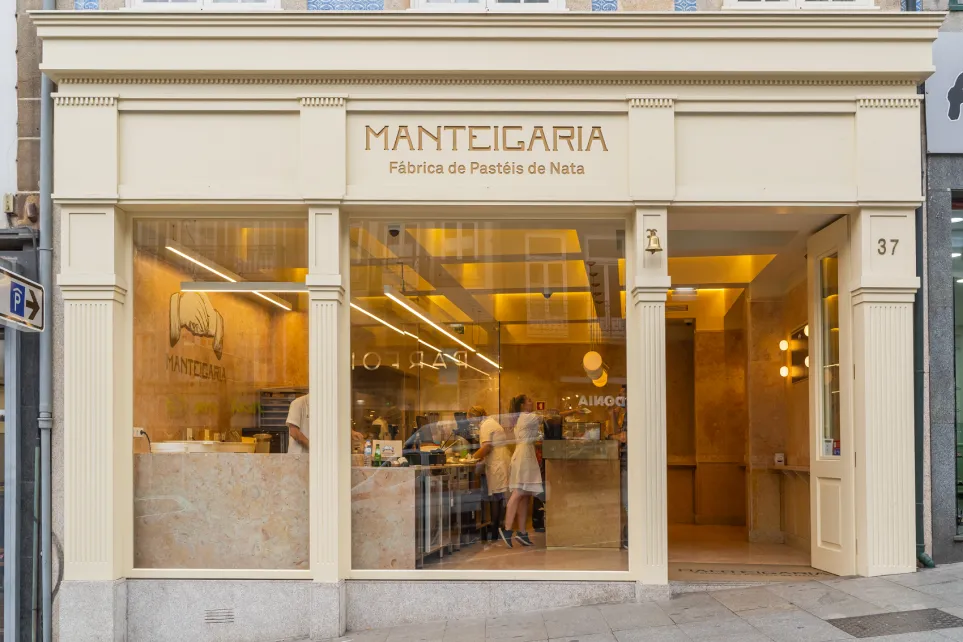 Fachada da Manteigaria no Porto, com o letreiro dourado Fábrica de Pastéis de Nata