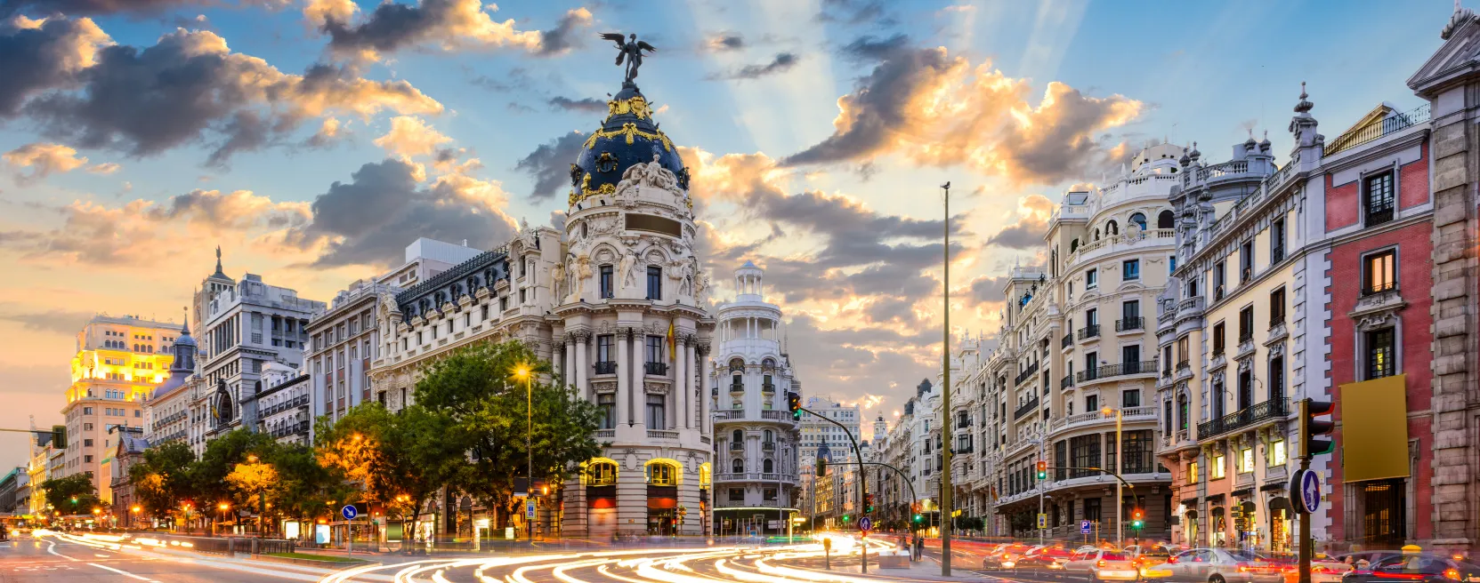 Edifício Metrópolis em Madrid ao entardecer, com trânsito em longa exposição na Gran Vía