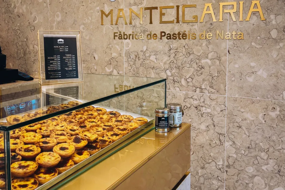 Manteigaria counter with pastéis de nata on display and the name engraved in gold