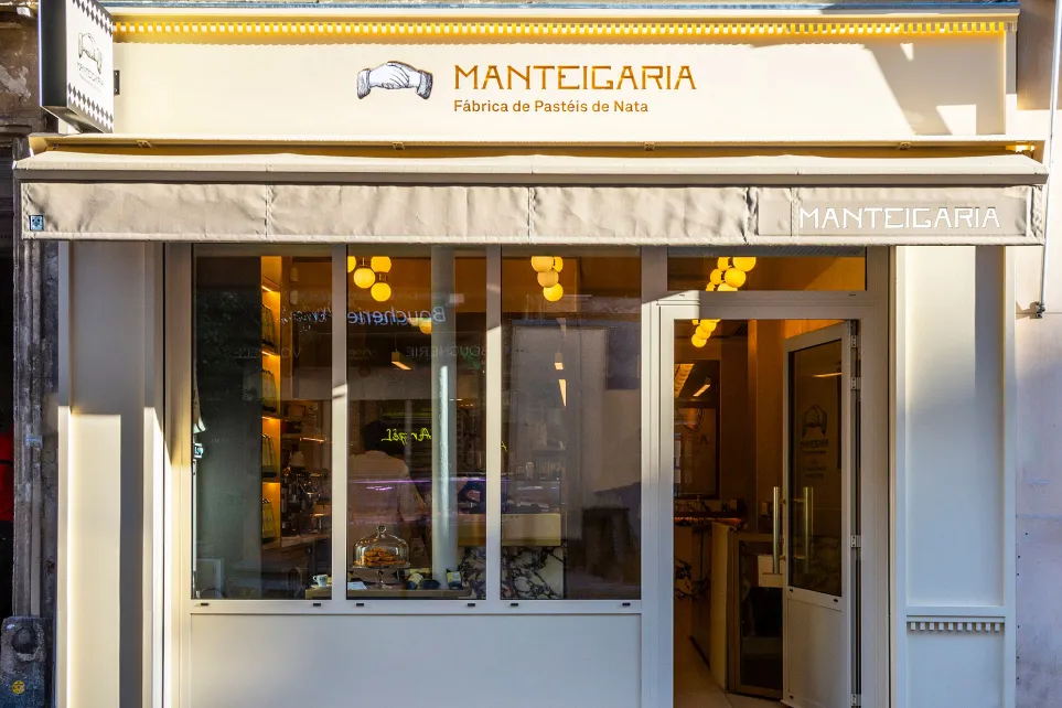 Fachada da Manteigaria em Paris, com toldo amarelo e letreiro em néon