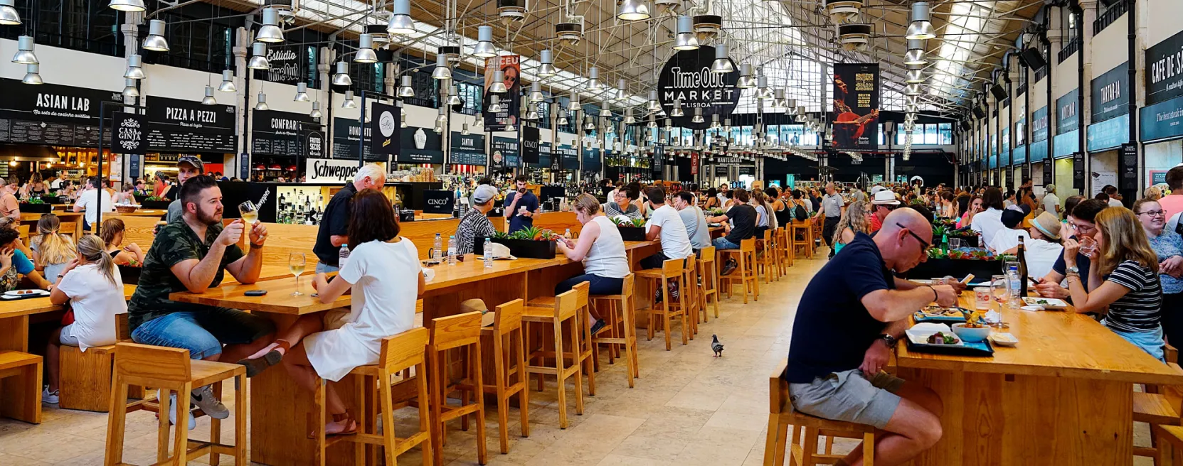 Intérieur du Time Out Market à Lisbonne, avec des tables communes et des stands de nourriture