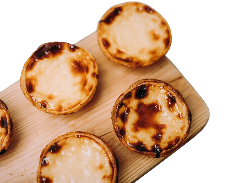 Pastéis de nata disposés sur une planche en bois