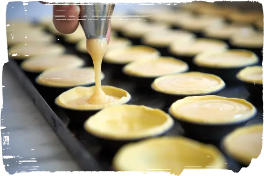 Crème versée sur la pâte dans des moules à pastel de nata