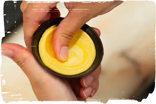 Mains façonnant la pâte dans un moule à pastel de nata