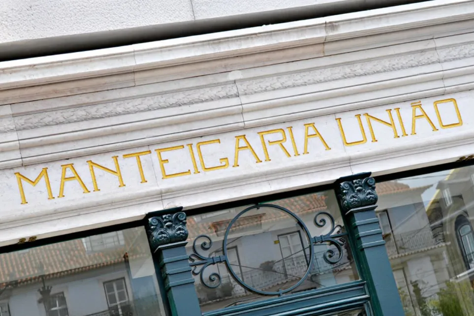 Fachada antiga com a inscrição dourada 'Manteigaria União', vestígio da antiga cooperativa de manteiga