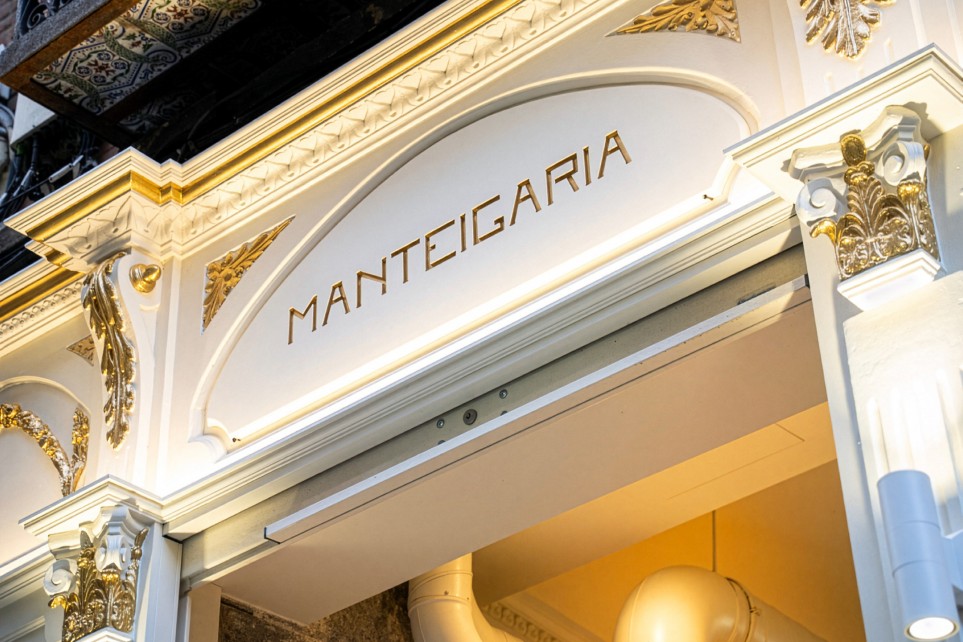 Entrada da docesecafe.live o nome gravado em dourado sobre estuque branco