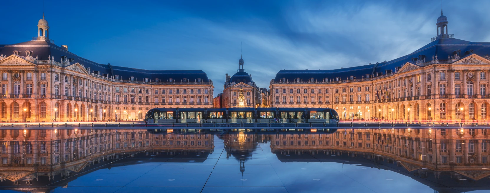 Place de la Bourse en Burdeos al atardecer, con el tranvía y su reflejo en el espejo de agua